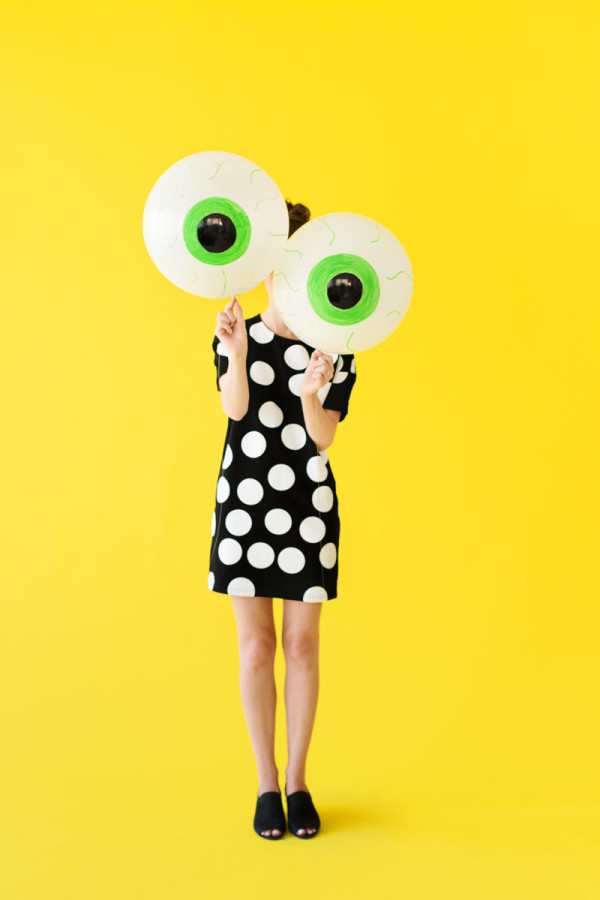 Someone holding eyeball balloons 