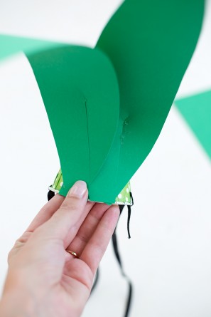 green paper leaves being glued to paper cup