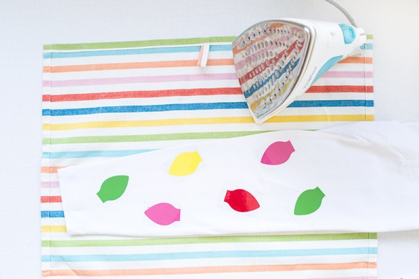 Someone ironing colorful patches on leggings
