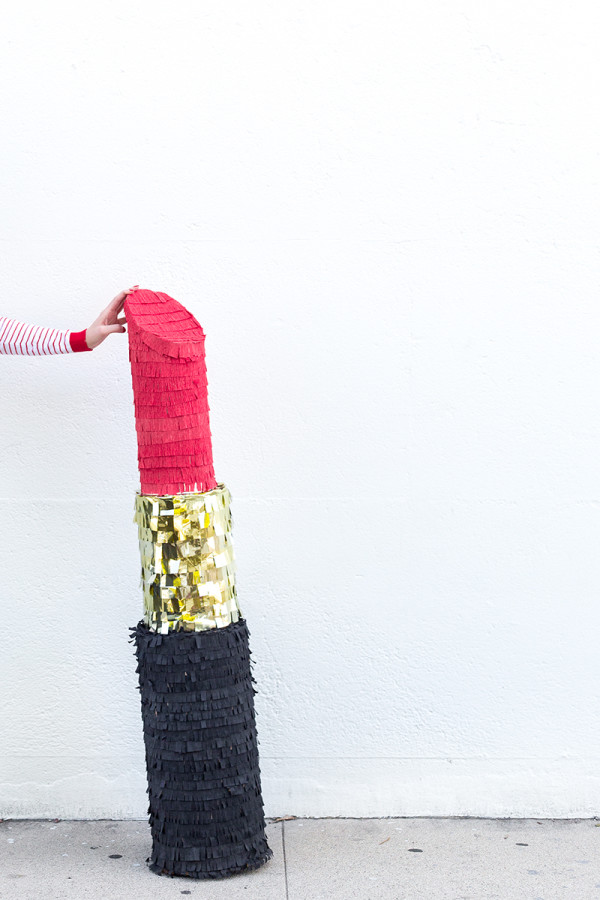 Someone holding a lipstick piñata