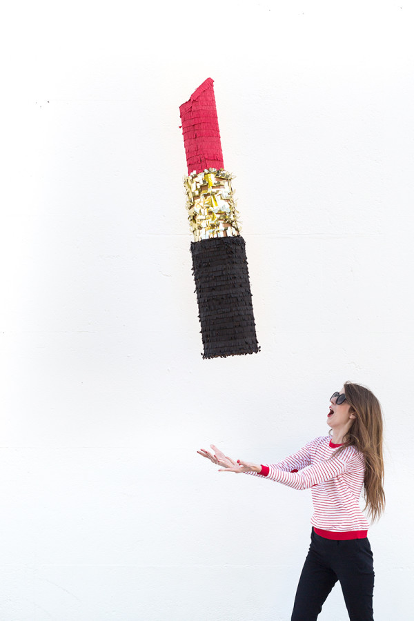 Someone throwing a lipstick piñata