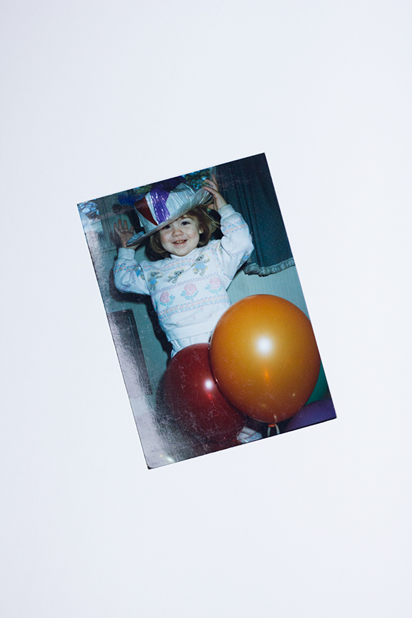 A photo of a little girl in a hat with balloons