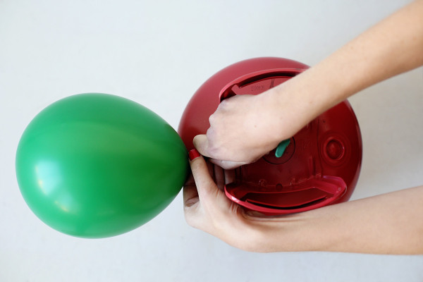 Someone blowing up a balloon