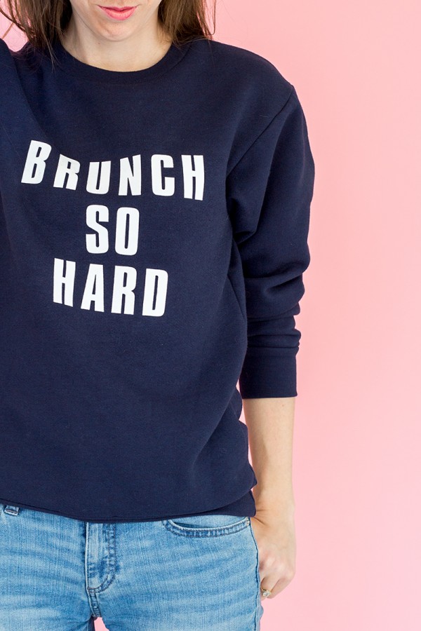 Someone wearing a blue crewneck that says \"brunch so hard\"