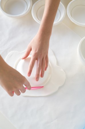 Someone cutting clay