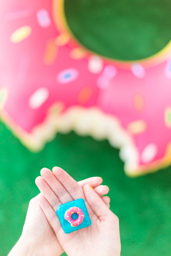 Someones hands and a donut in the background