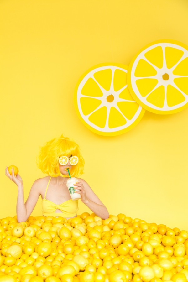 A woman sitting in lemons and drinking a drink