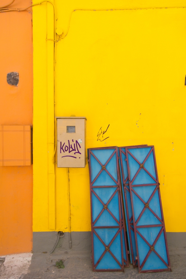 A yellow and orange building with blue windows