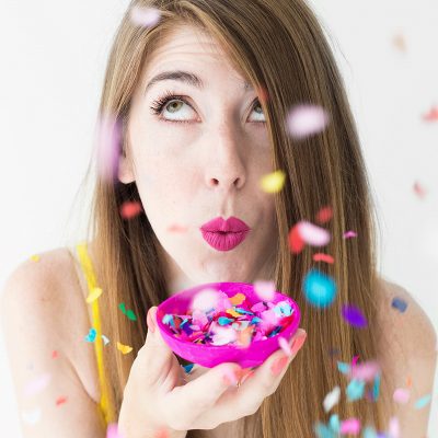 Lipstick 101: Two Ways To Make Your Lipstick Last A woman holding a pink tray with confetti