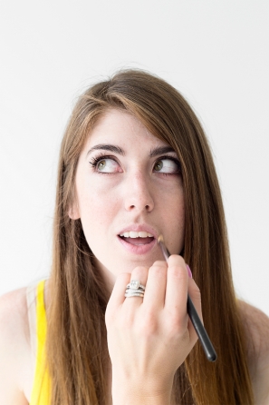 A woman getting her lips painted