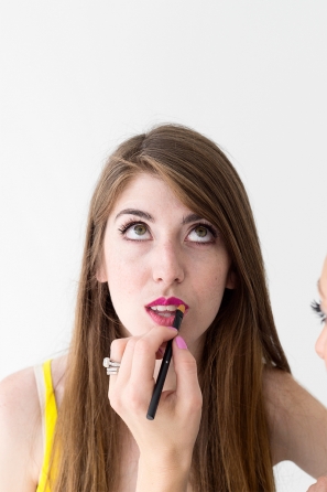 Someone putting lip product on