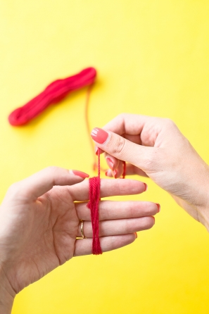 Someone wrapping red string