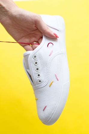 White sneakers with colorful strings on them