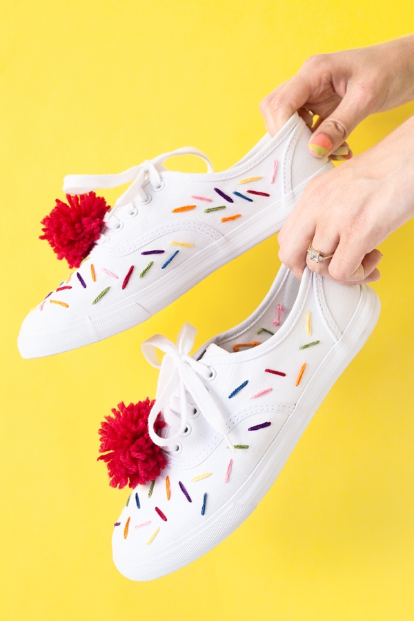 Sneakers with colorful strings and red pom poms