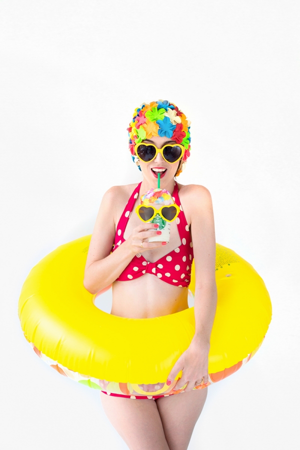 A woman wearing a bikini and holding a starbucks drink