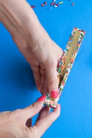 Someone holding a paper with sprinkles and gold paper