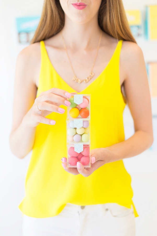 A woman wearing a yellow shirt and holding candy