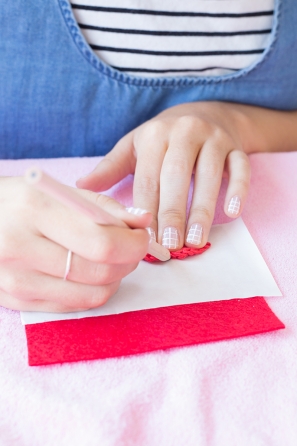 Someone putting a red item on pink fabric
