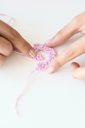 Someone sewing a pink shape