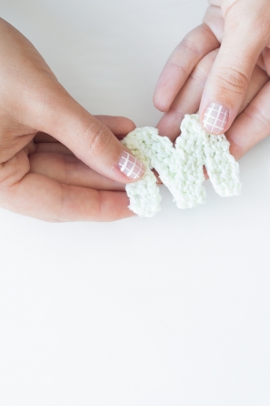 Someone holding a knitted \"M\" 