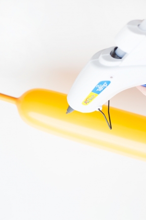Someone gluing a yellow balloon
