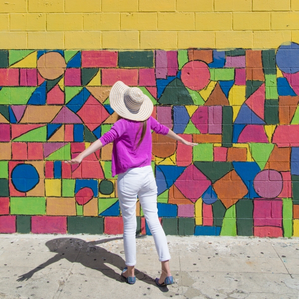A woman in front of a colorful wall