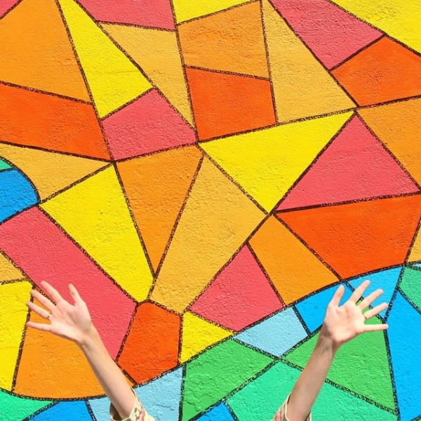 Someone standing in front of a colorful mural