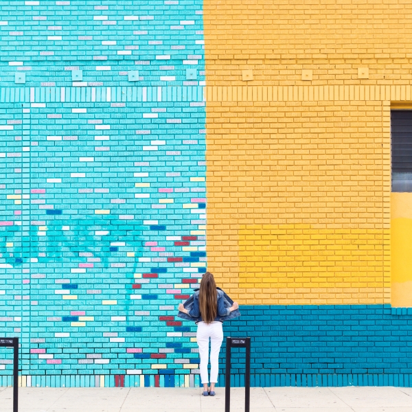A woman in front of a colorful wall