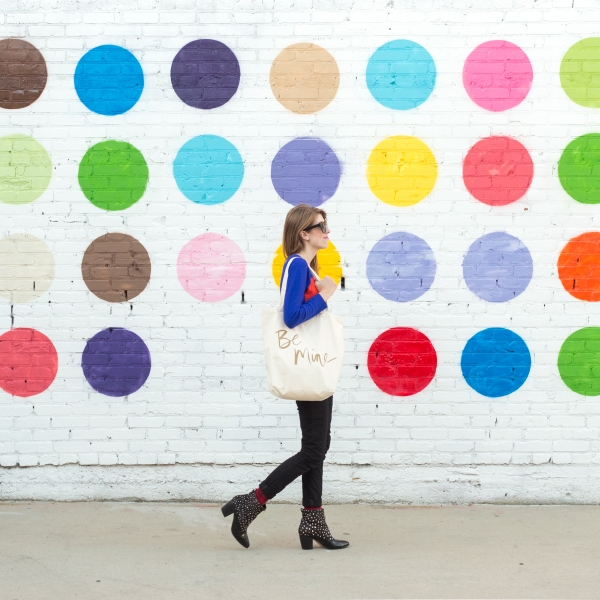 A woman in front of a wall with colorful polka dots