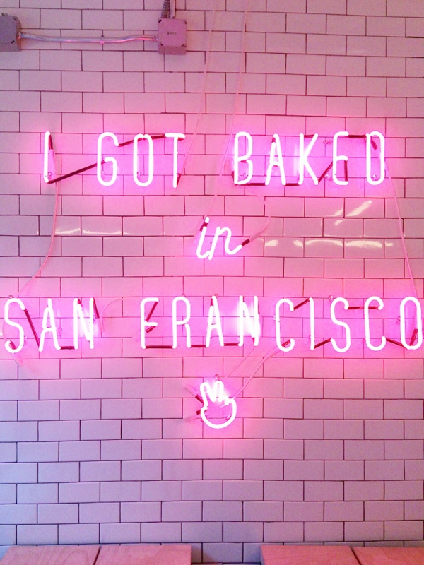 A pink neon sign on a wall