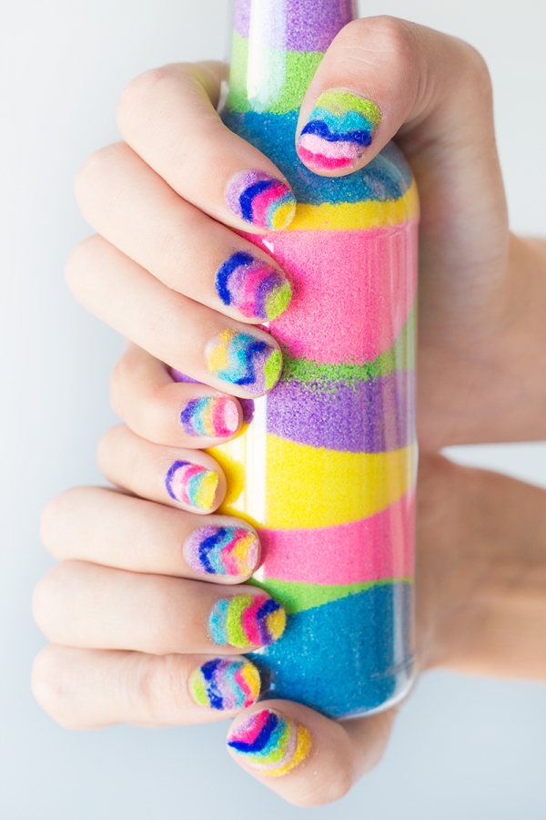 Someone holding rainbow powder in a jar