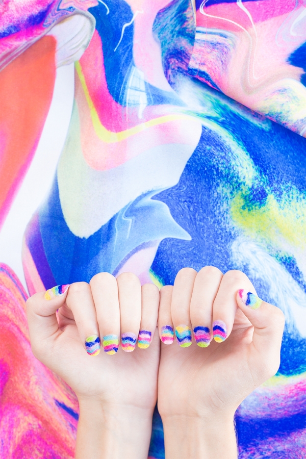 Hands with rainbow powder nails