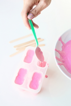Someone putting pink liquid in a tray