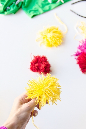 Someone holding a yellow yarn flower