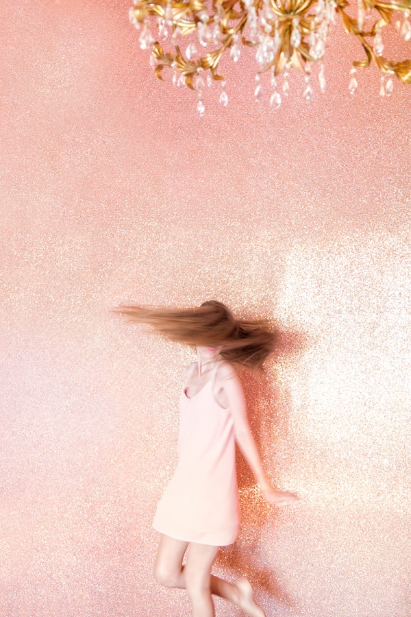 Someone spinning in front of a pink wall