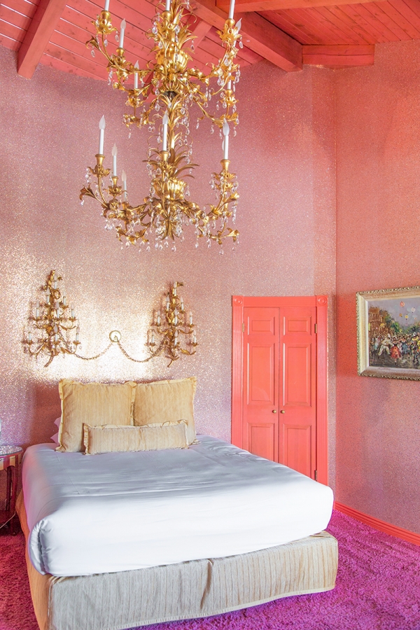 A bedroom with a large bed and chandeliers