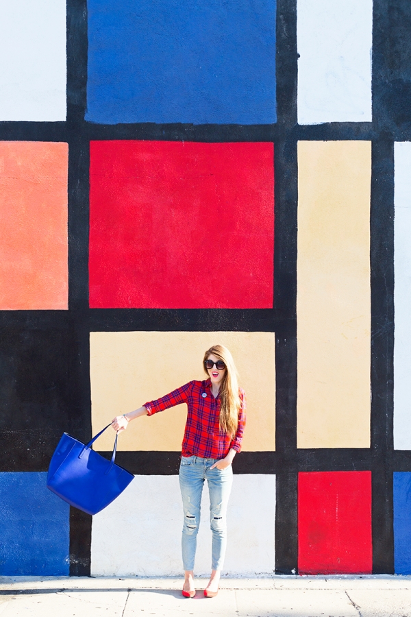 A woman standing in front of a colorful wall