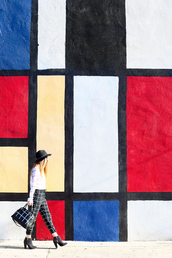 A woman standing in front of a colorful wall