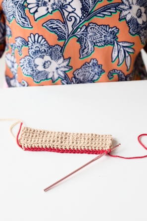 Someone sewing something beige and red