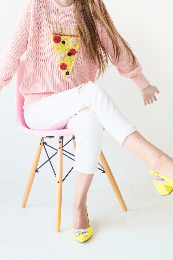 Someone wearing a pizza sweater and white jeans