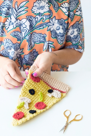 Someone sewing a slice of pizza