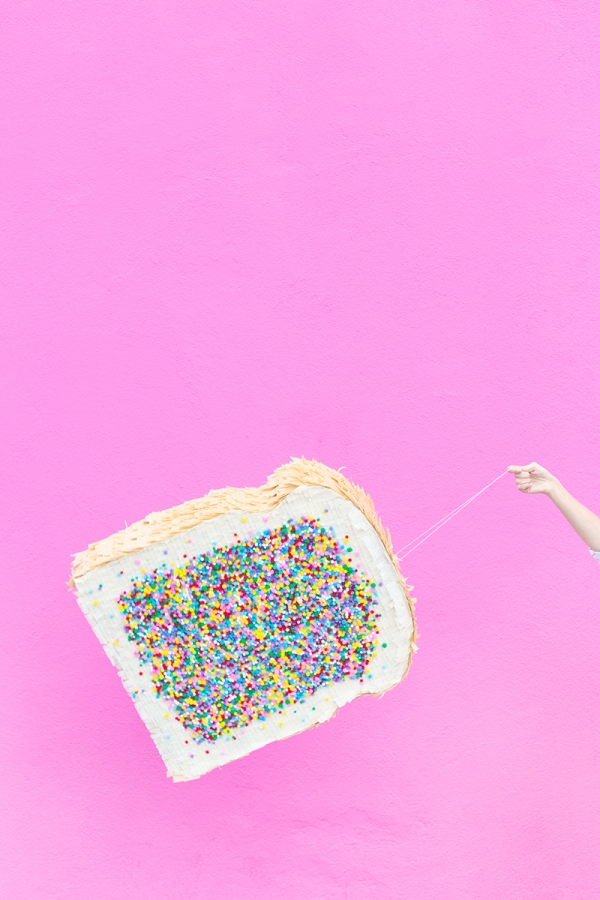 A woman holding a fairy bread pinata