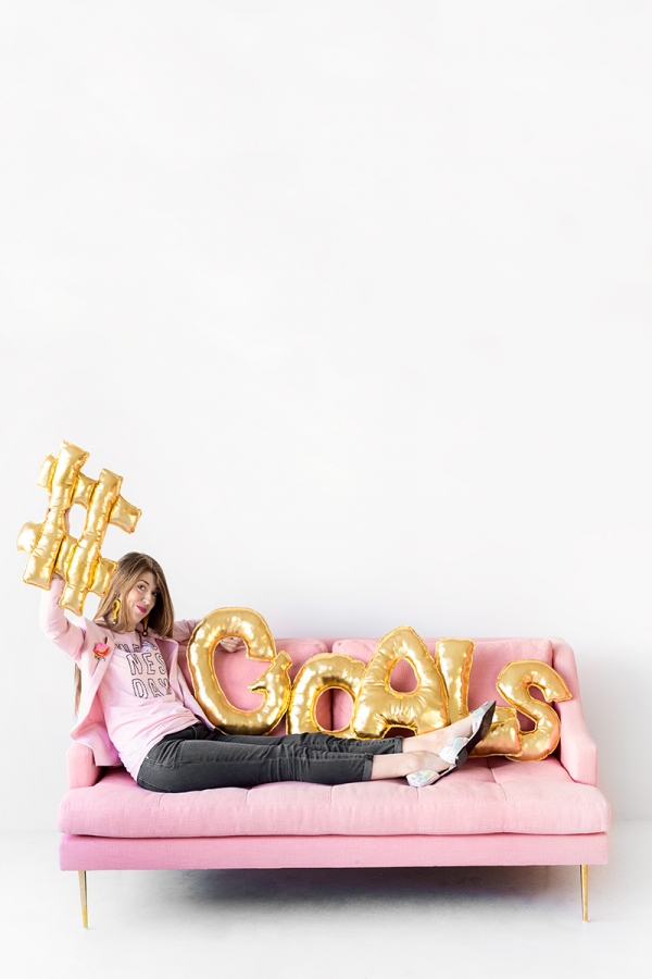 A woman sitting on a couch with gold balloons