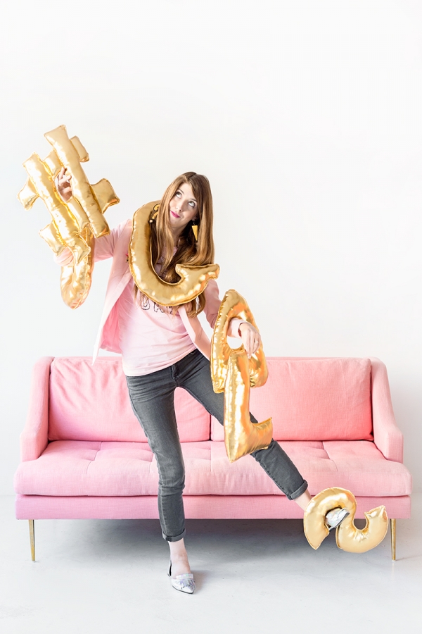 Someone holding a bunch of gold balloons