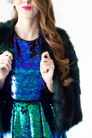 A close up of someone wearing a blue dress and black jacket