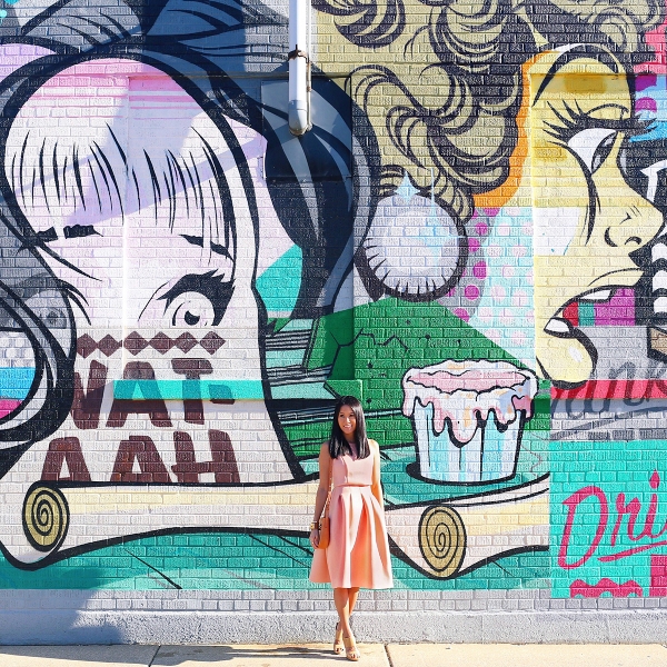 A woman standing in front of a colorful wall
