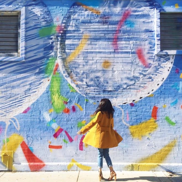 A woman standing in front of a colorful wall