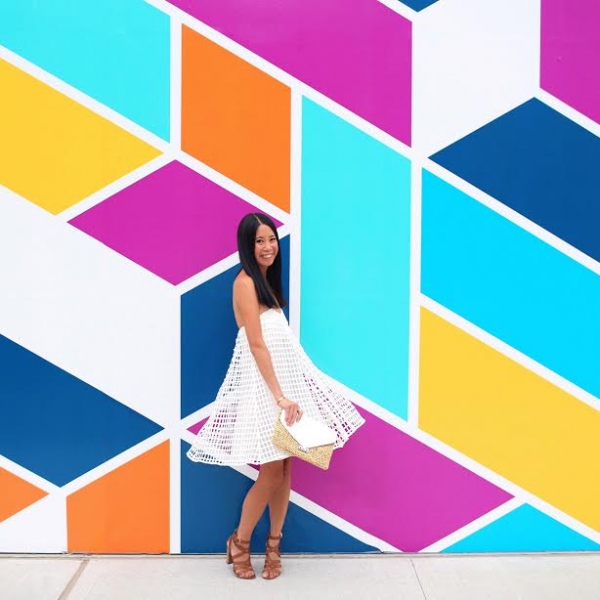 A woman in front of a colorful wall