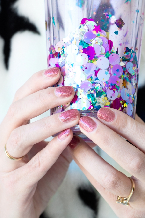 Someone holding a glitter cup