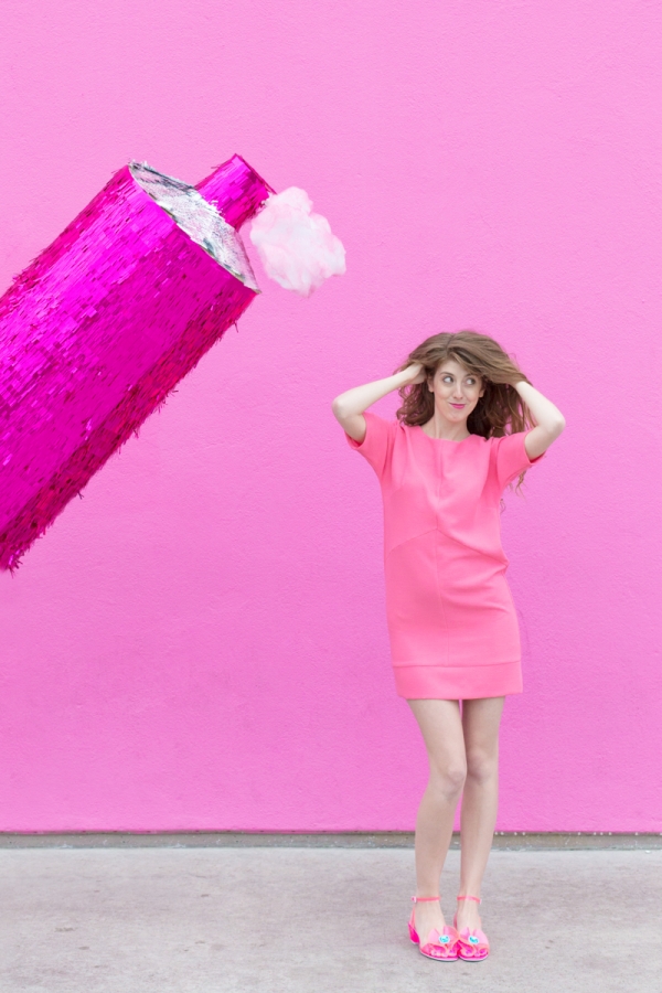 Pink hairspray pinata and a woman in a pink dress